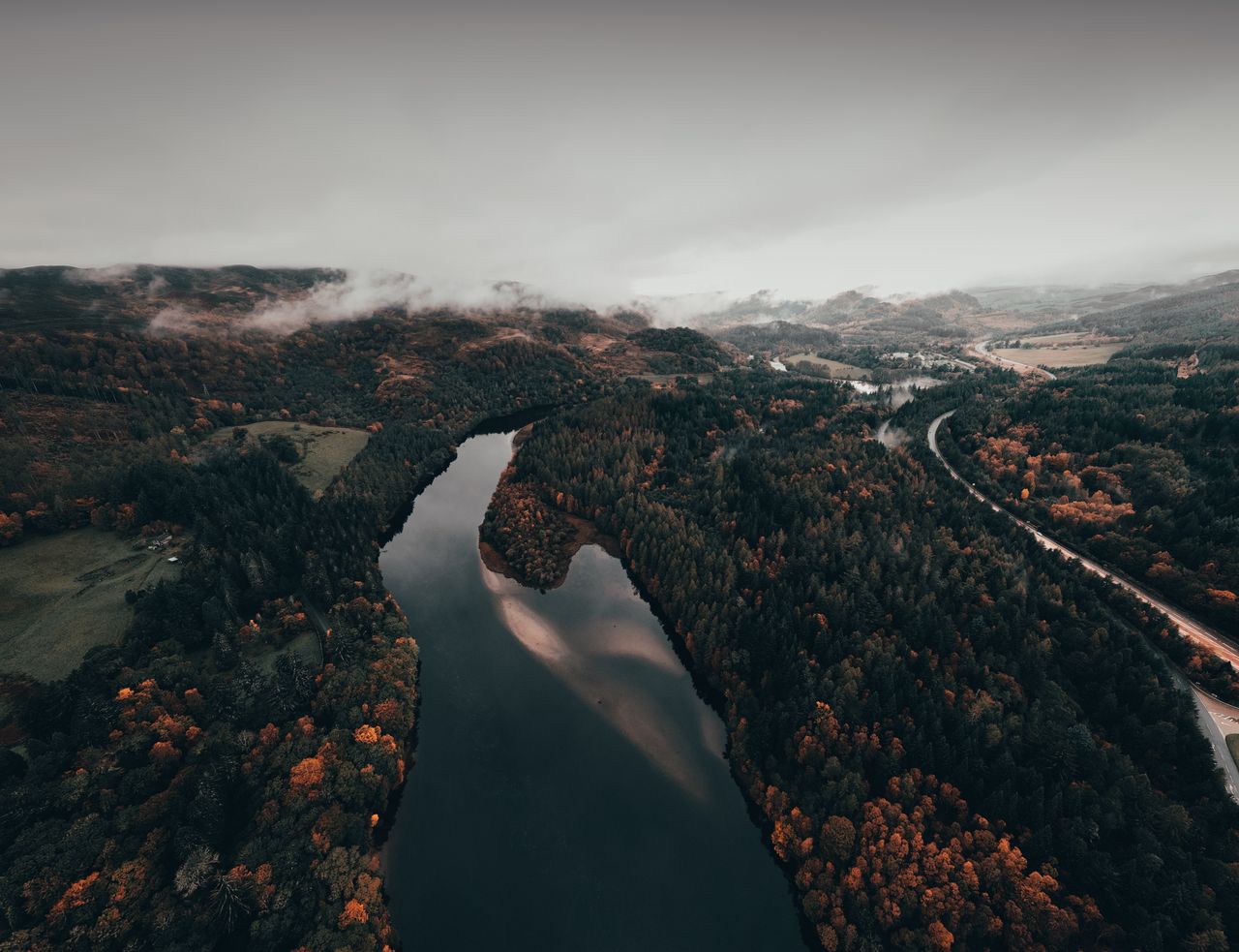 a captivating aerial view of a river cutting through a forest during a