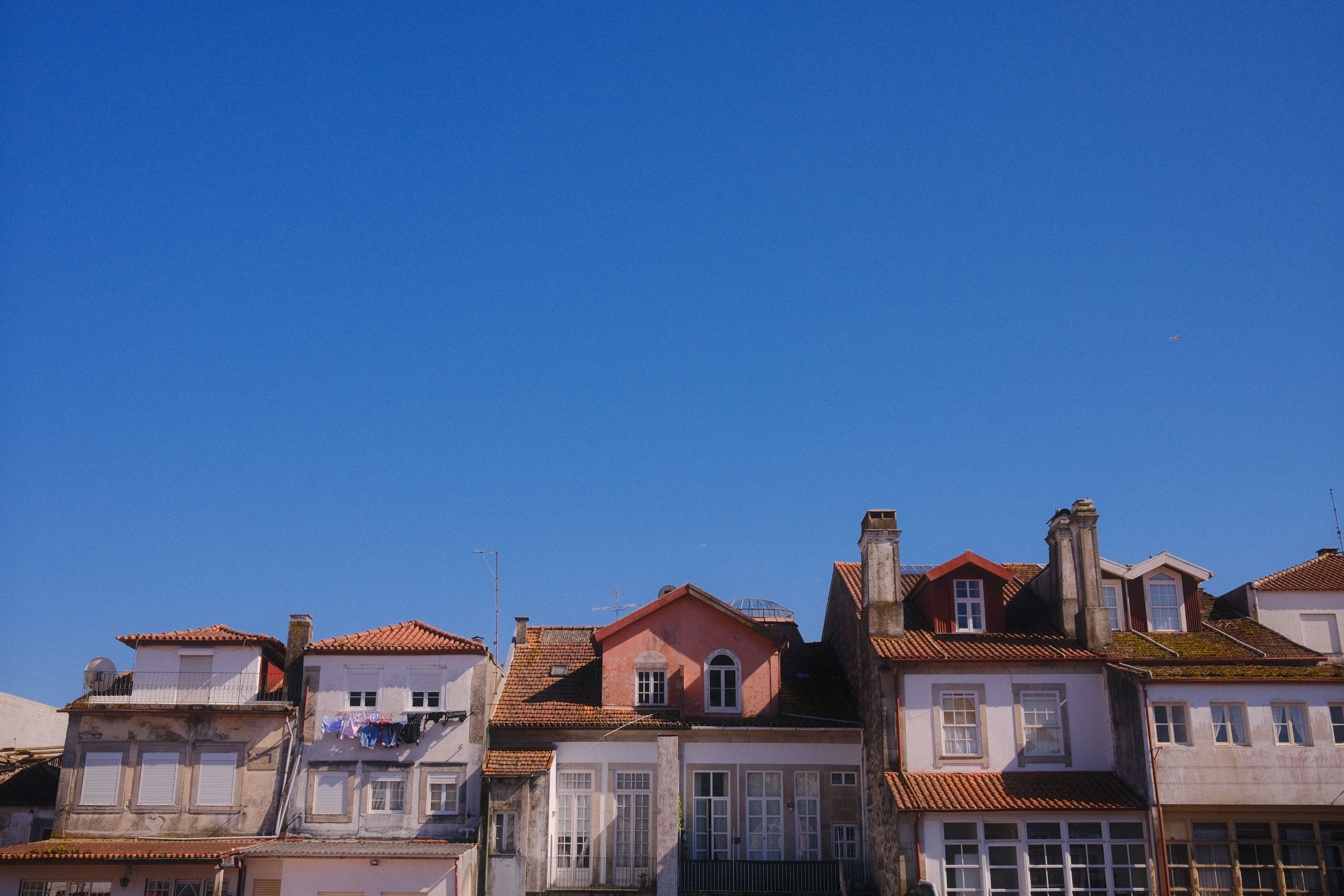 Picturesque view of colorful rooftops against a clear blue sky in Viana do Castelo, Portugal.