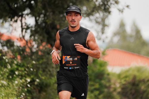Free Athletic male runner participating in an outdoor marathon, wearing black sportswear. Stock Photo