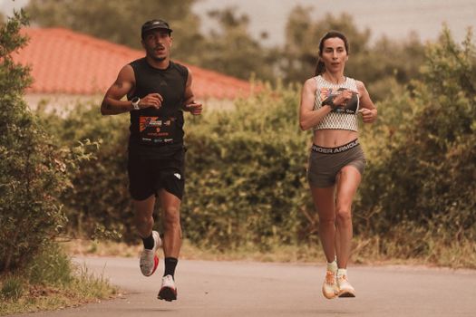 A man and woman jogging on an outdoor path, showcasing fitness and healthy lifestyle.