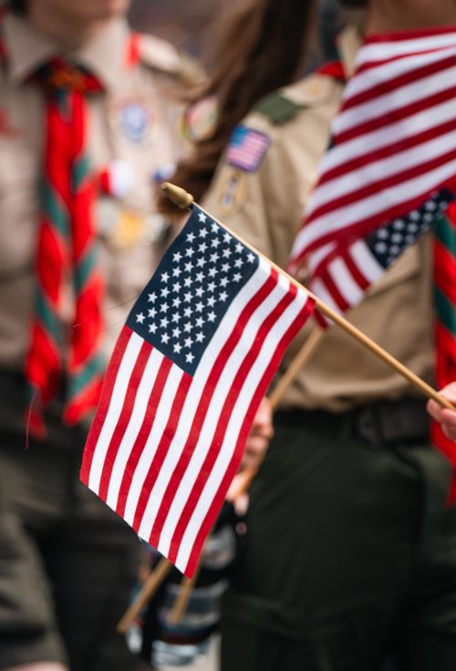 Free Boy Scouts in uniform holding American flags, showcasing patriotism and unity. Stock Photo
