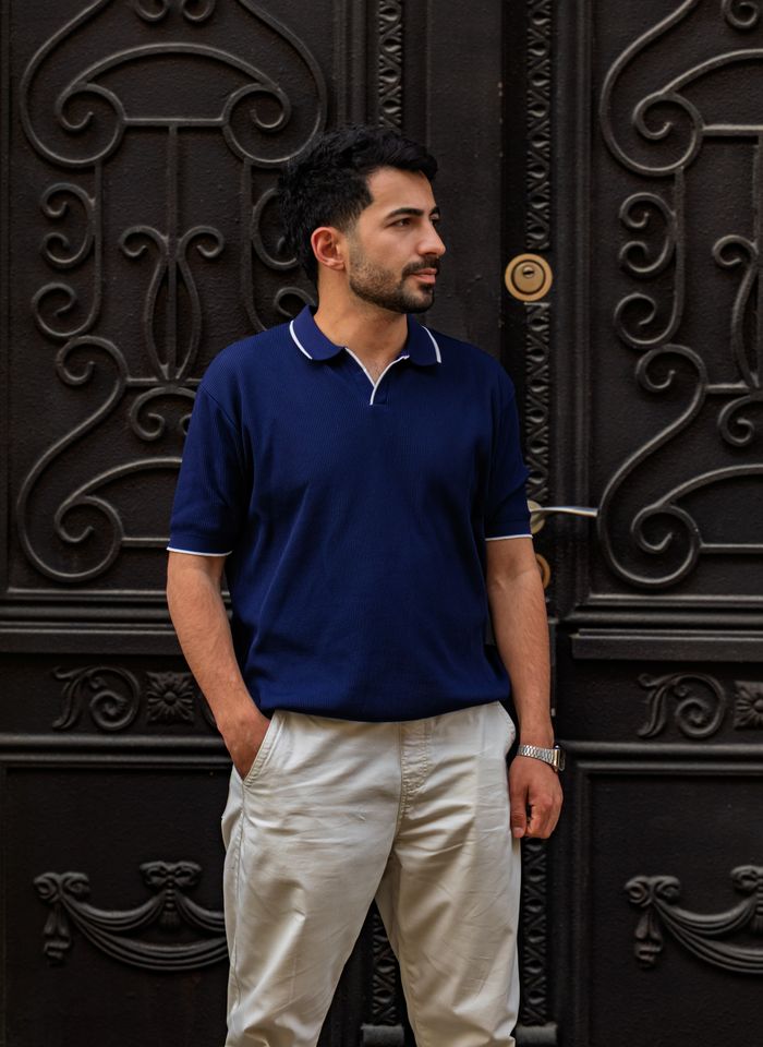 Cream tapered trousers worn with a navy knit polo — photo by Yusif Iskandarov on Pexels