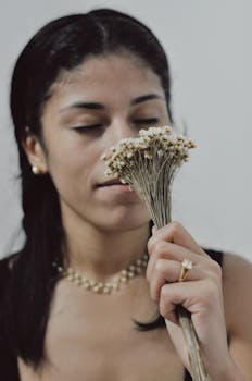 特写一个女人欣赏一束优雅的白花