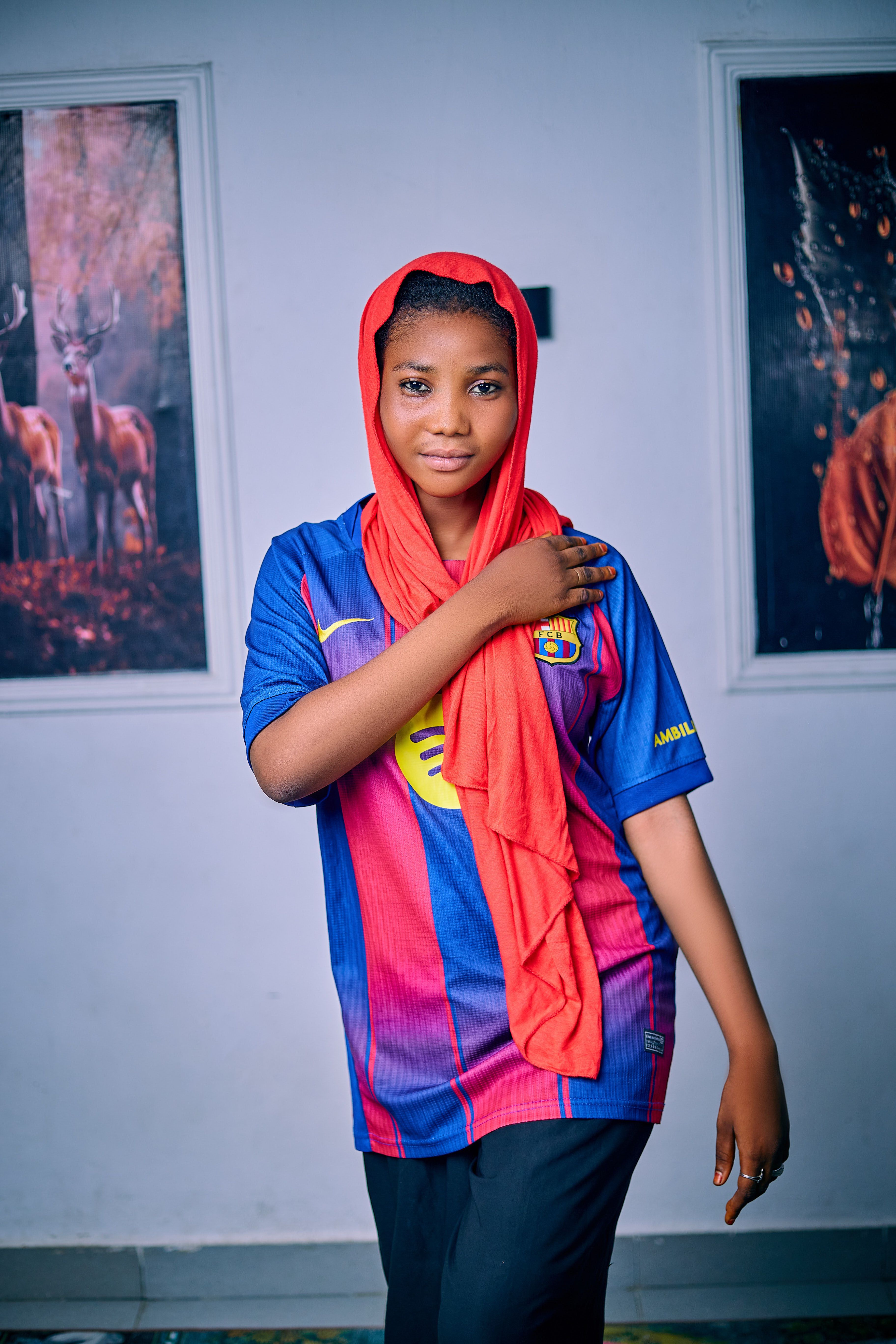 Portrait of a woman in a soccer jersey indoors with art background.