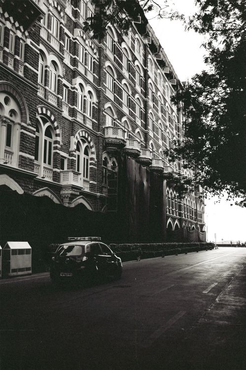 Free Classic black and white image of historic Mumbai hotel facade on a quiet street. Stock Photo