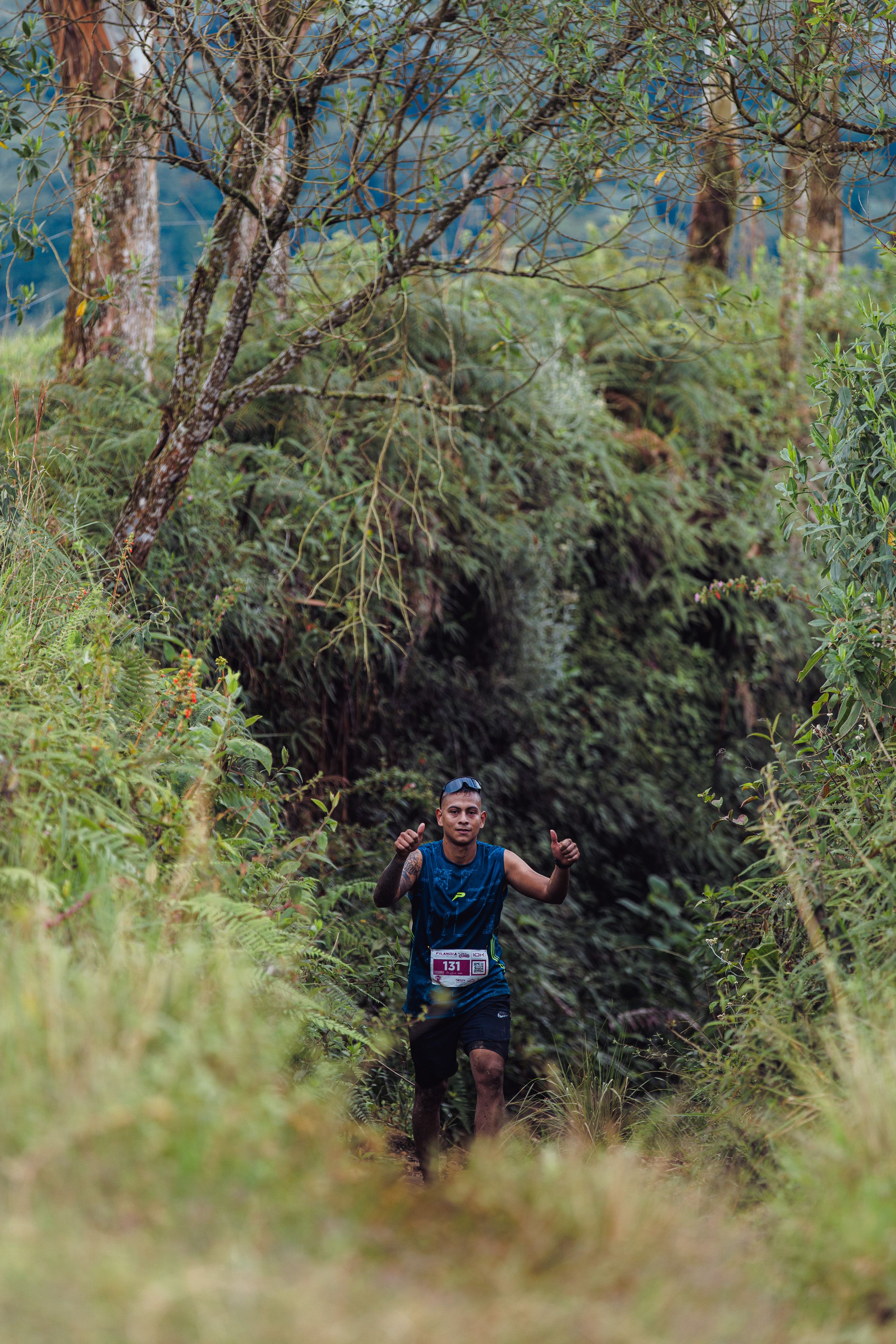 A determined trail runner making his way through lush forested terrain.