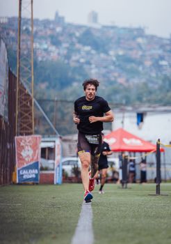 Determined athlete running on an outdoor track during a city marathon event.