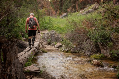 Free A senior hiker traverses a scenic creek in the lush wilderness of Sheridan, Wyoming. Stock Photo