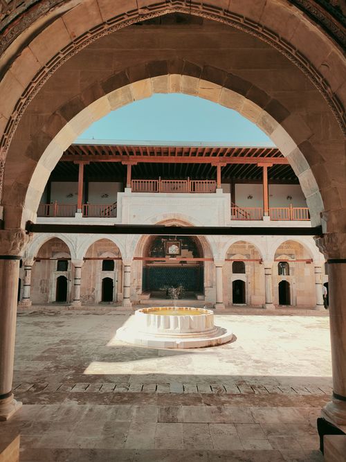 Free A serene view of a historic courtyard archway in Sivas, Türkiye, bathed in sunlight. Stock Photo