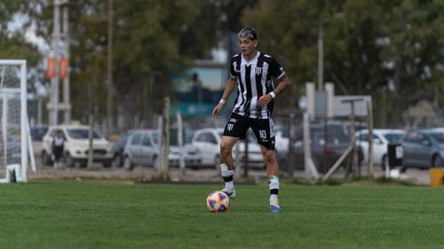 Free Dynamic image of a soccer player in black and white uniform on the field. Stock Photo