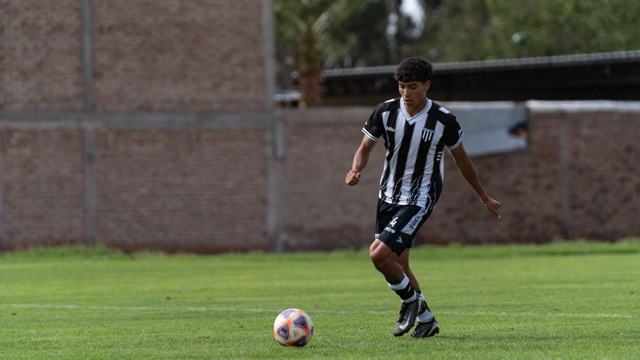young male soccer player dribbling on an outdoor field