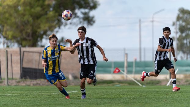 Action shot of teenage boys playing soccer, demonstrating competition and athleticism on the field.