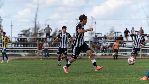 Young soccer players compete on a grass field during a match, showcasing teamwork and athleticism.