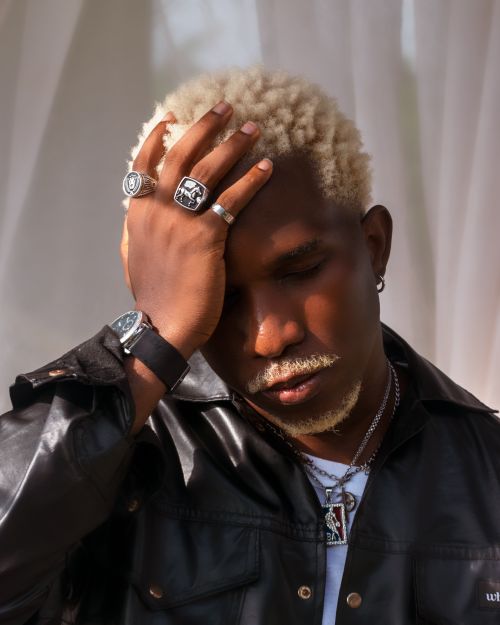 Free Stylish man with blonde hair in a leather jacket, wearing rings and a watch. Stock Photo