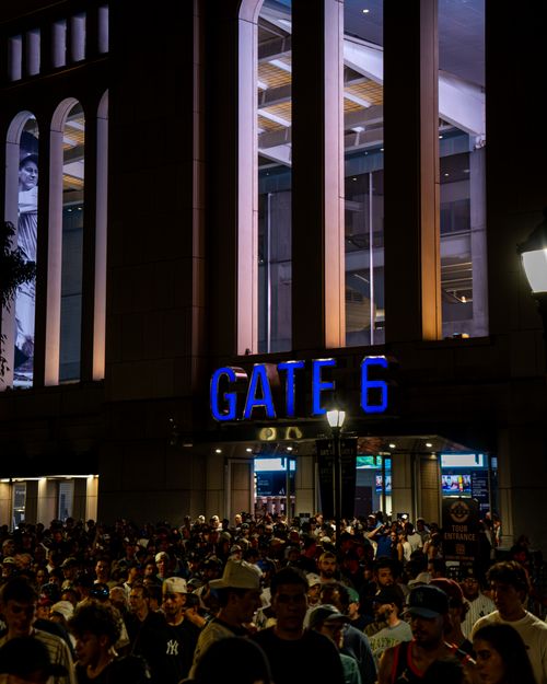 Free A large crowd gathers at Gate 6 of a stadium, illuminated at night, creating a vibrant and lively atmosphere. Stock Photo