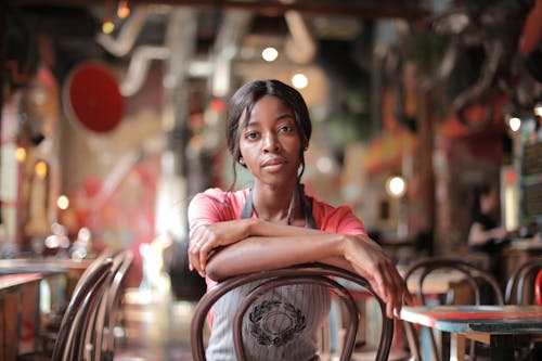 Woman in Pink Shirt Sitting on Chair