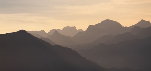 Free Beautiful mountain silhouette with sunrise hues creating a serene landscape. Stock Photo