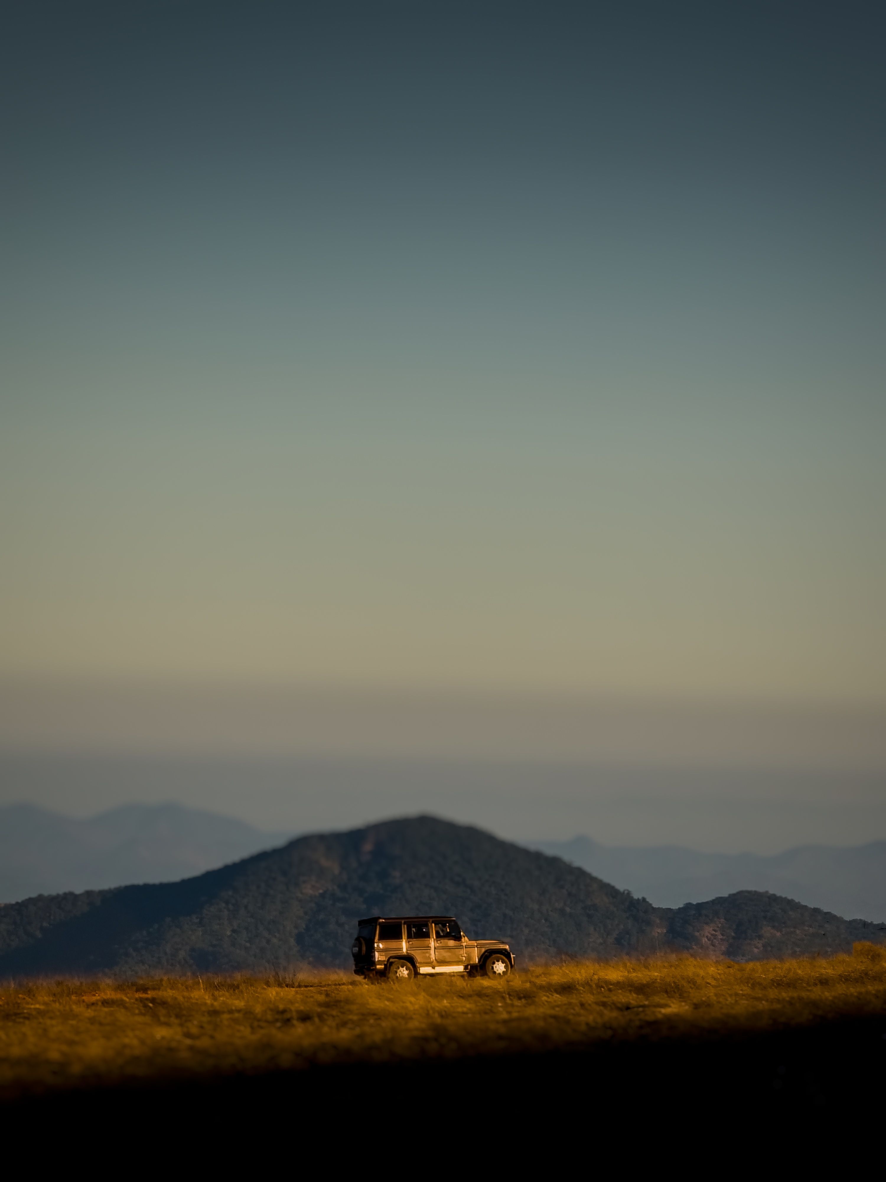 An off-road vehicle set against the stunning backdrop of Gudisa's mountainous terrain under a clear sky.