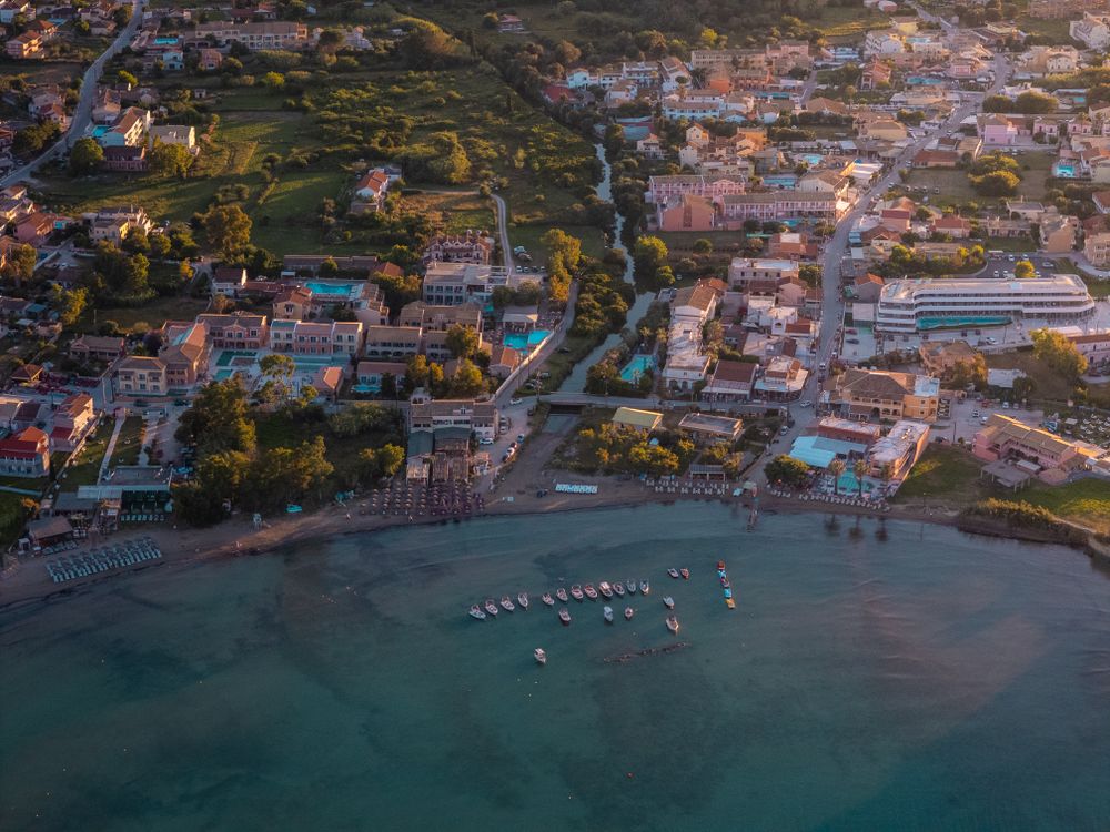 Sat de coastă din Corfu cu bărci, la apus de soare