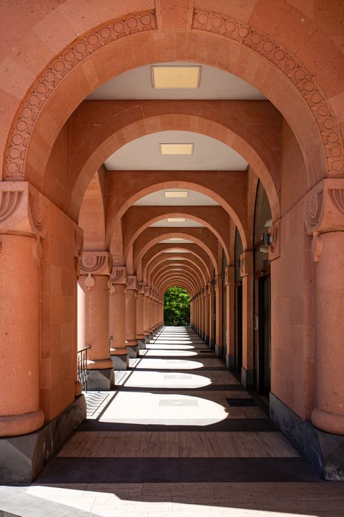 Free Sunlit architectural corridor featuring elegant arches and intricate details. Stock Photo
