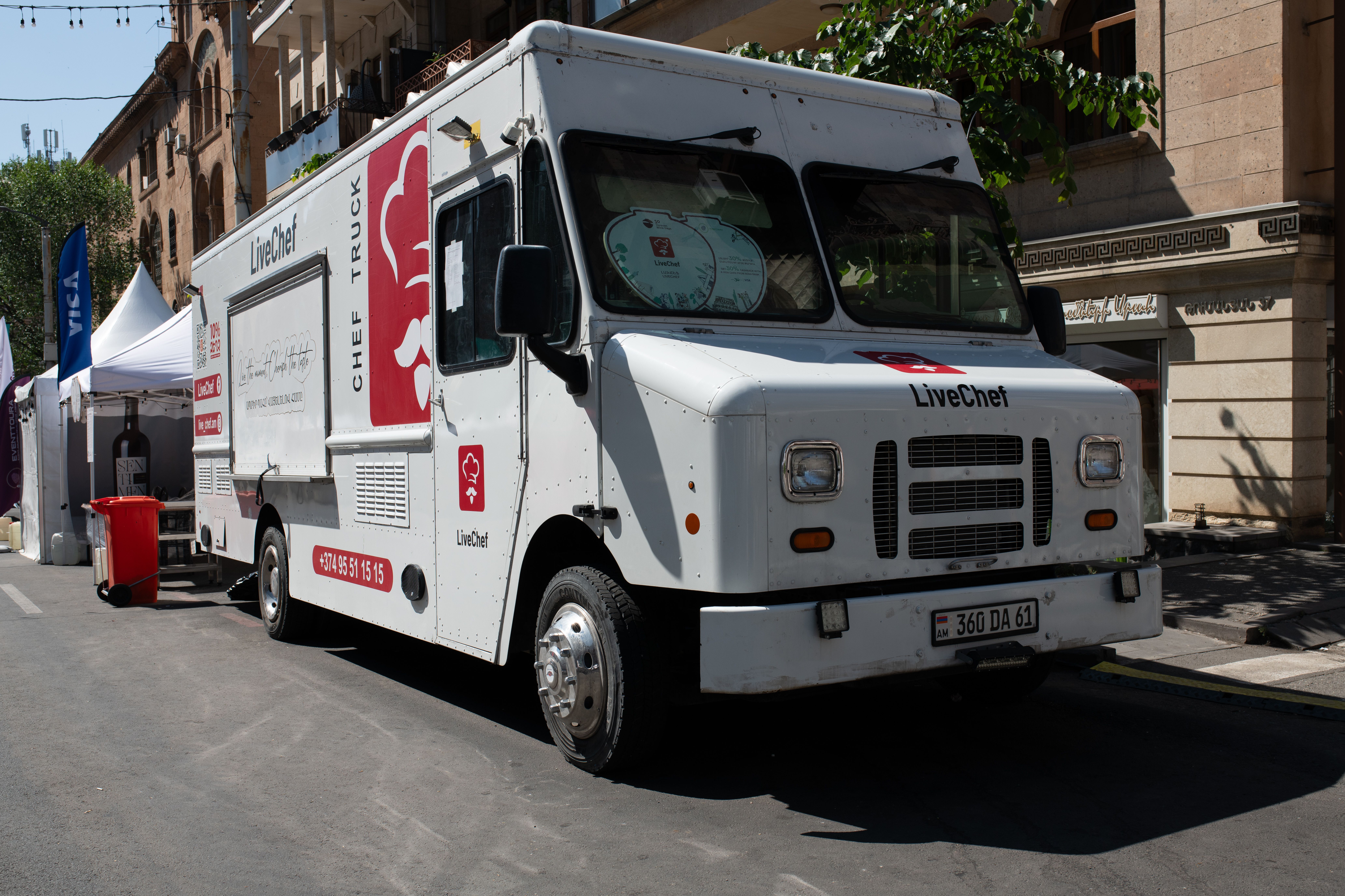 Modern white food truck serving customers at a busy outdoor street festival