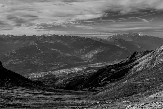 Captivating black and white view of the Swiss Alps, with striking mountain ranges and dramatic sky.