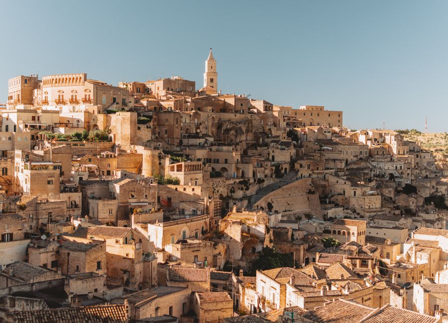 Explore the ancient stone dwellings of Matera, Italy, a UNESCO World Heritage site bathed in golden light.