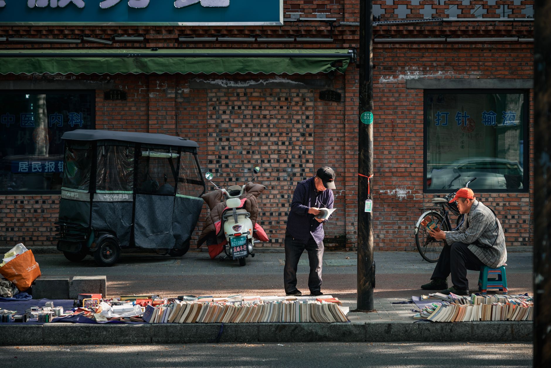 healthy ageing book — Two men interacting at a street book market, showcasing urban lifestyle.