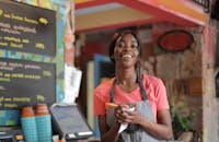 Shallow Focus Photo of Woman Smiling While Holding Pen and Paper