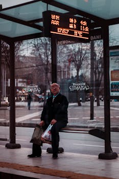冬天，城市里的老人提着购物袋在公交车站等车