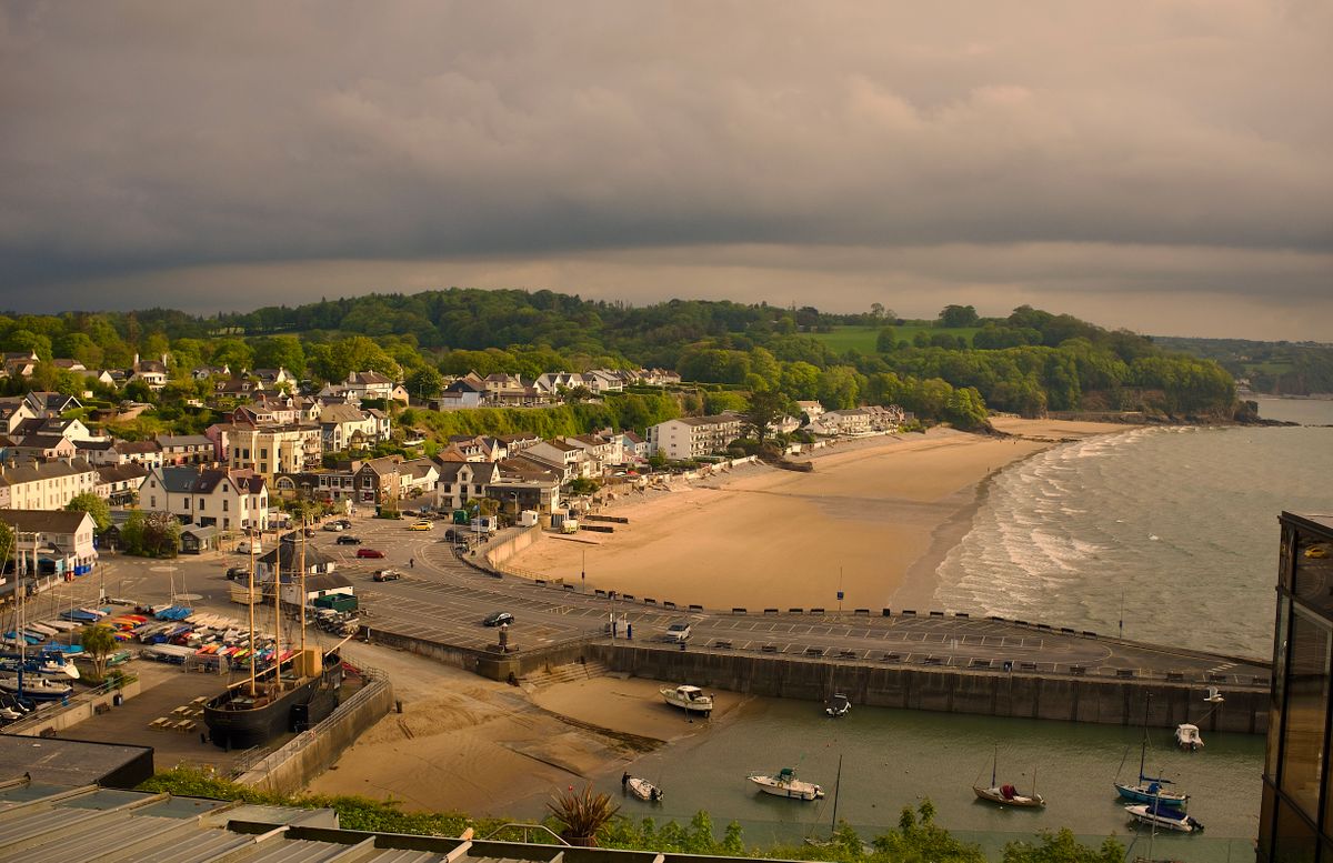 Tenby holiday harbour with fishing boats below the seafront and North Beach