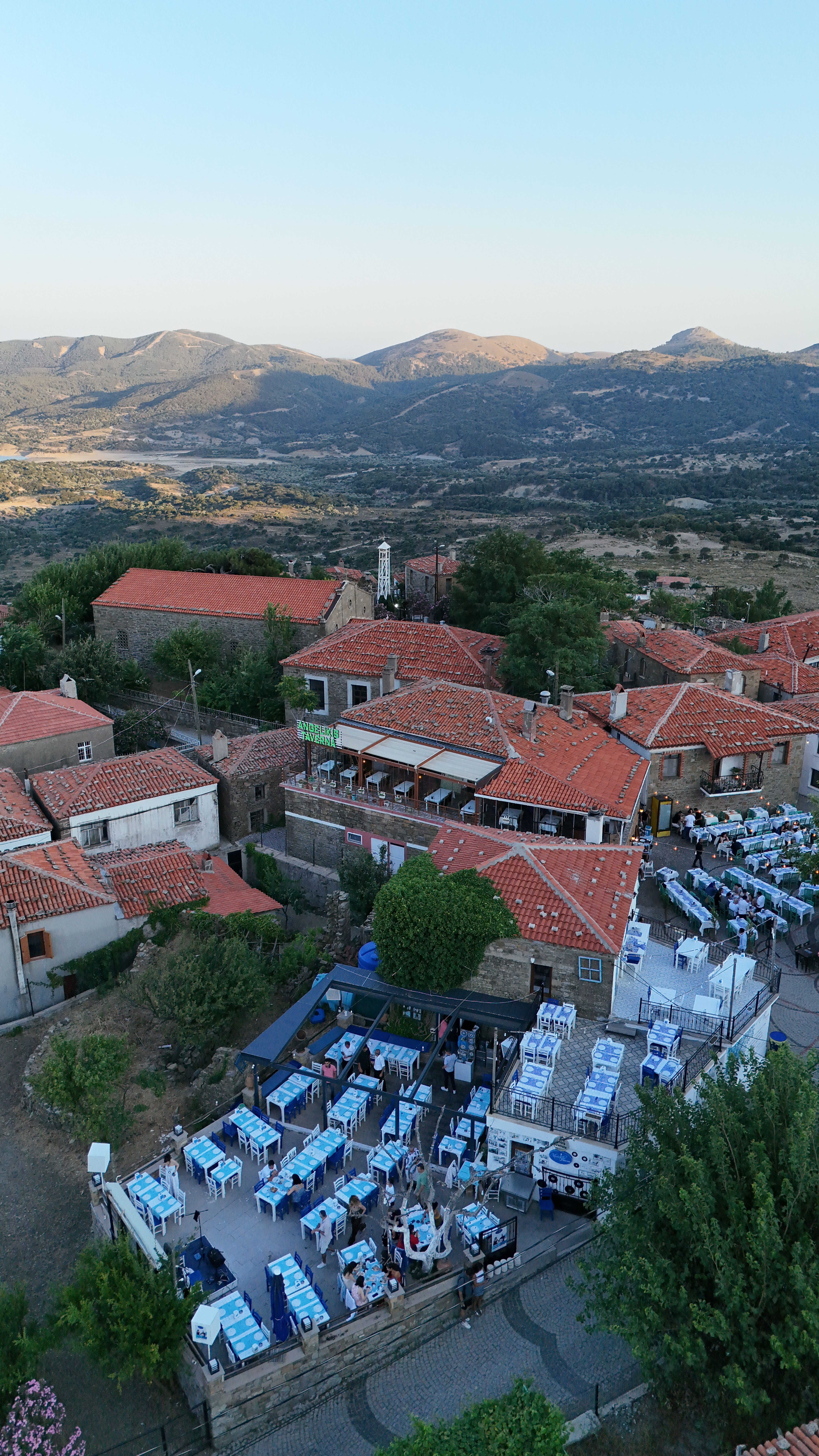 Charming village in Gökçeada, Türkiye with red rooftops and scenic mountains in the background.