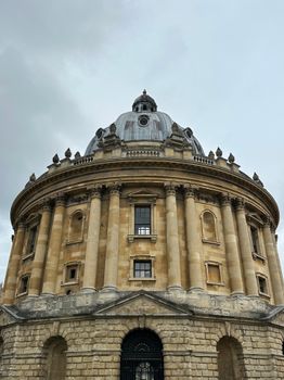 Historic Radcliffe Camera with its iconic dome, a landmark of Oxford University, captured on a cloudy day.
