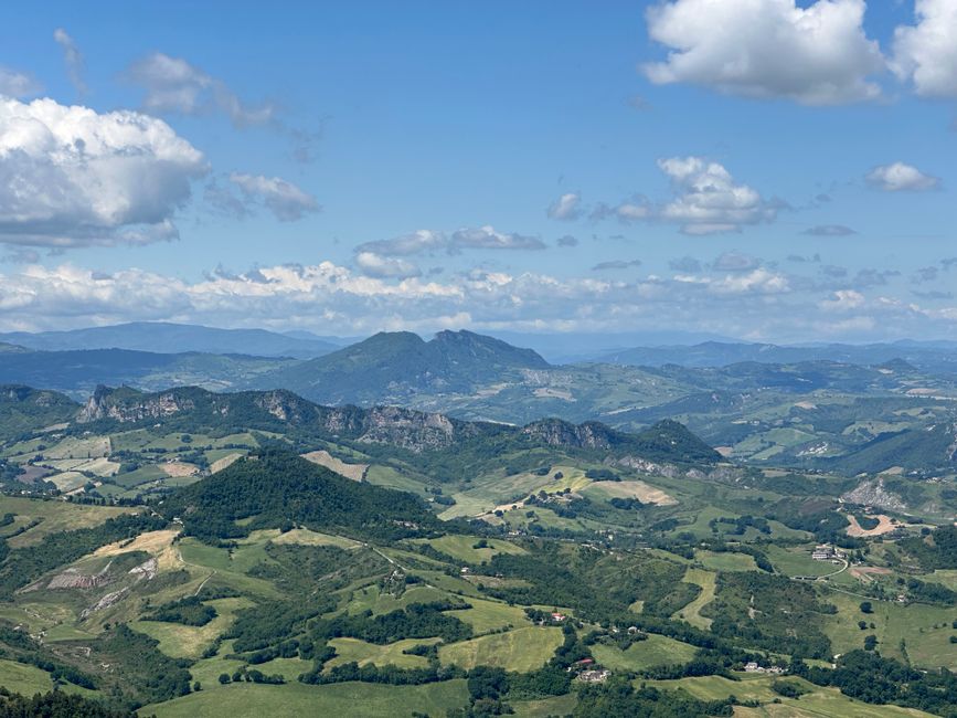 Discover the lush, rolling hills and expansive landscape of San Marino under a stunning blue sky.
