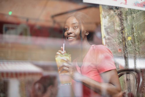 Free Young woman with glass of juice in cafe Stock Photo