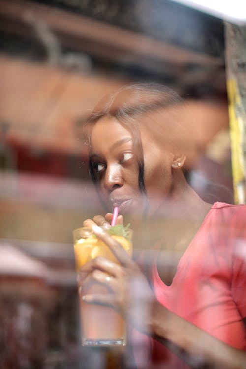 Young female drinking cocktail with straw
