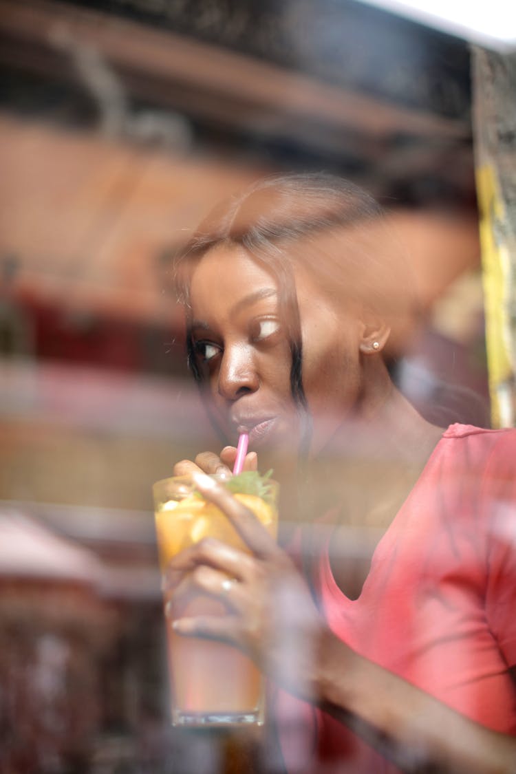 Young Female Drinking Cocktail With Straw