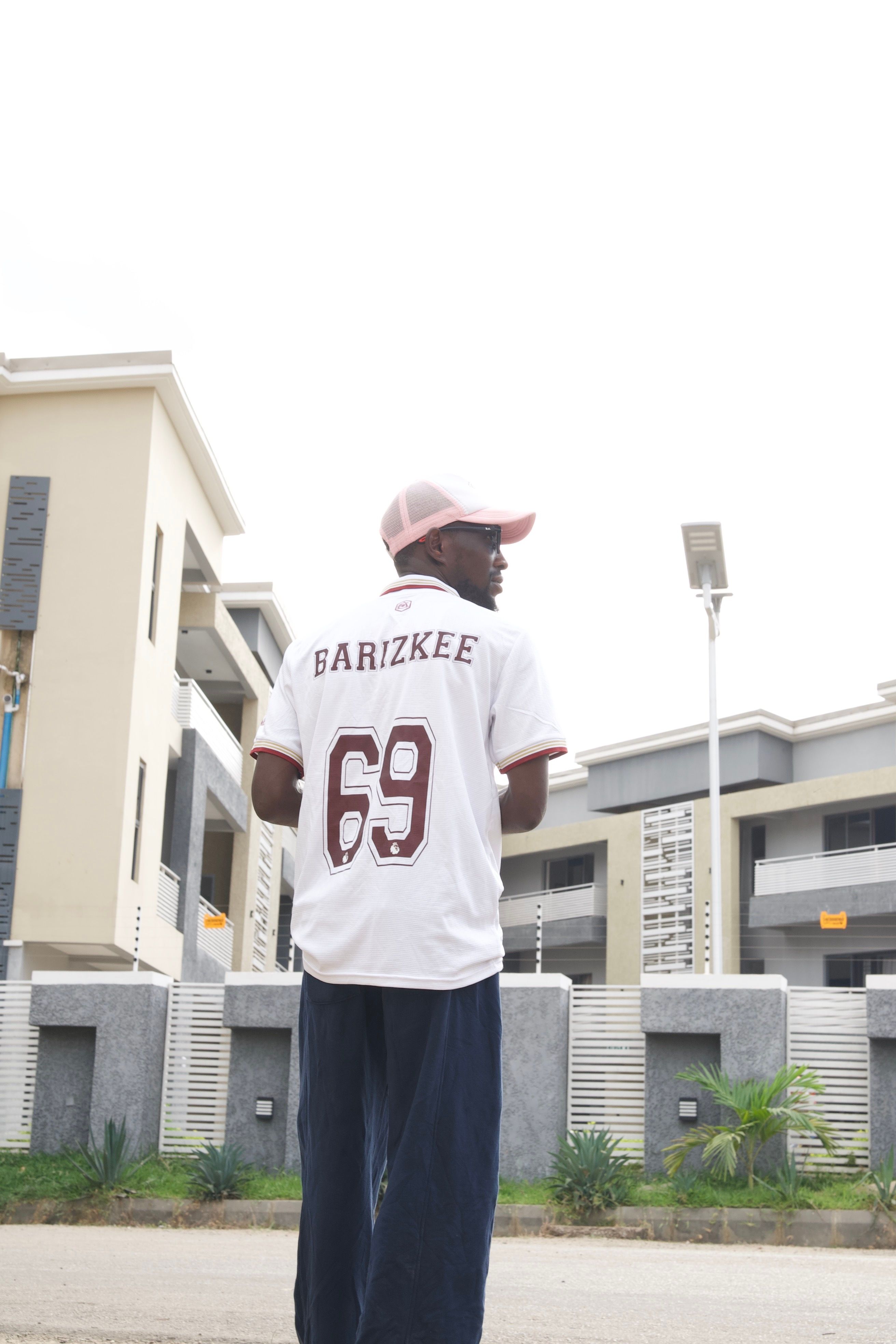Young man in streetwear on a city street in Abuja, Nigeria, showcasing urban lifestyle.