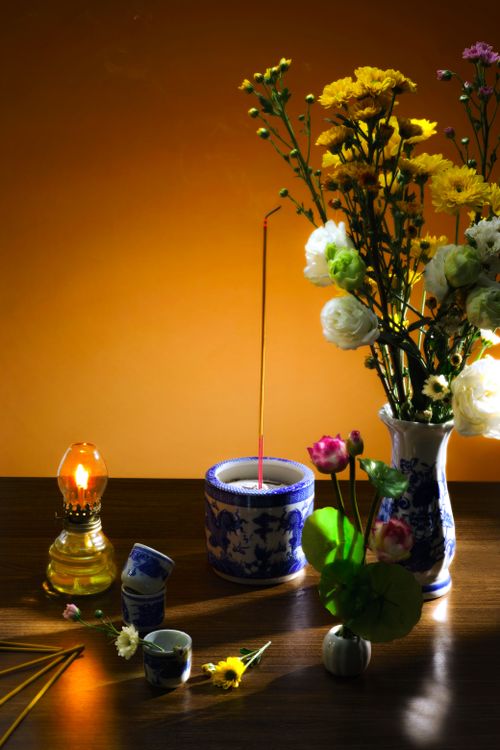 Free Elegant flowers, incense, and lamp create a serene setting on a wooden table. Stock Photo