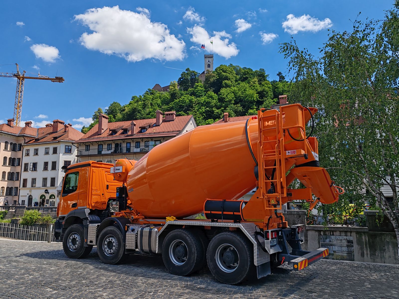 Orange concrete mixer truck in a town