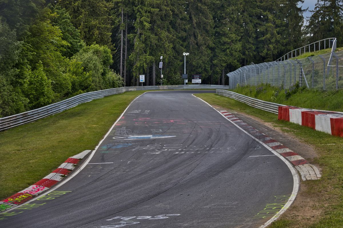 Asfalt de circuit in urcare, cu graffiti pe suprafata