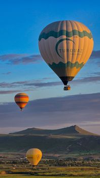 Stunning hot air balloons soaring over Cappadocia, Türkiye, during a vibrant sunrise.