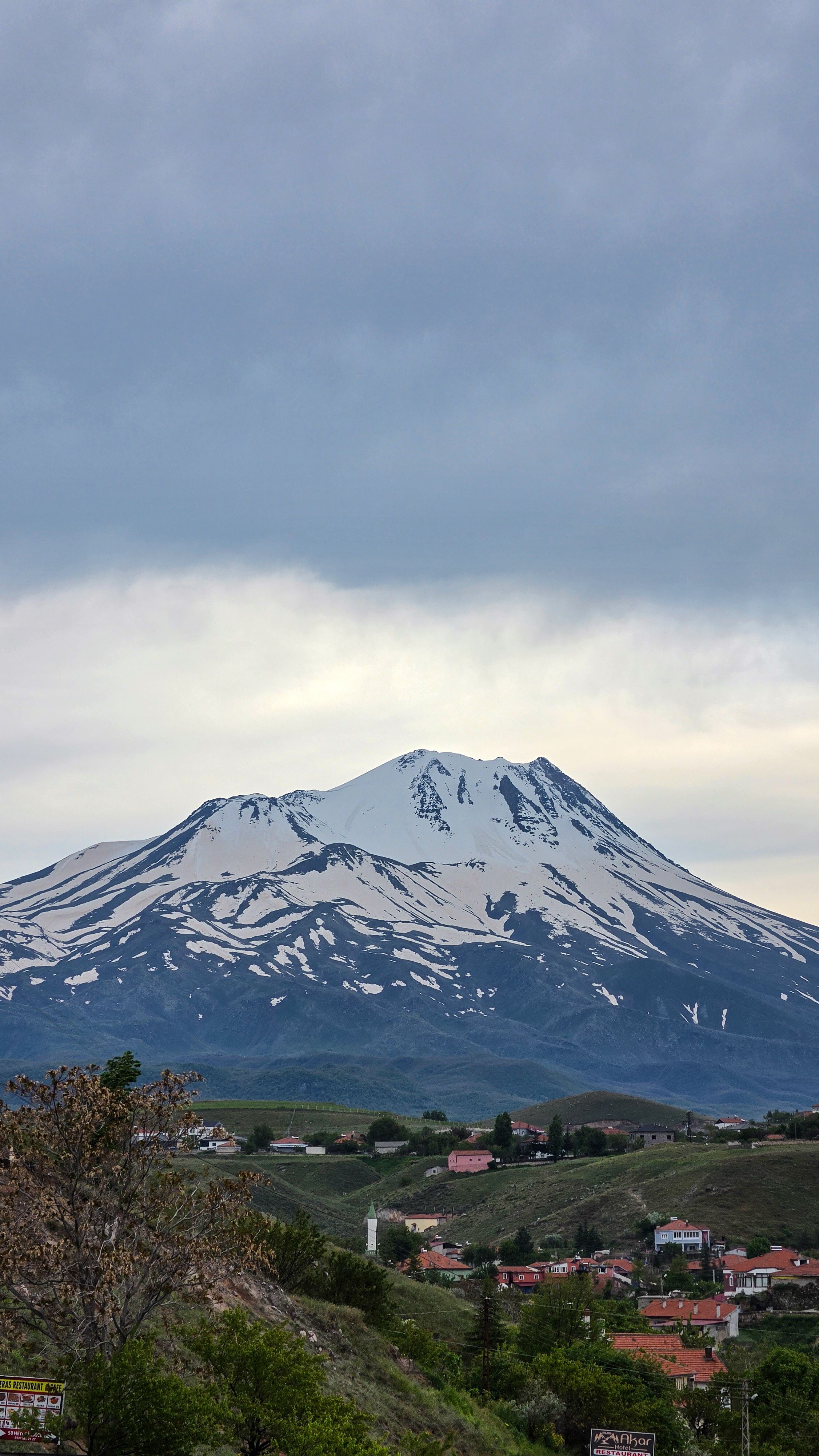 Scenic view of snow-capped Hasan Mountain under cloudy sky in Türkiye, capturing natural beauty.