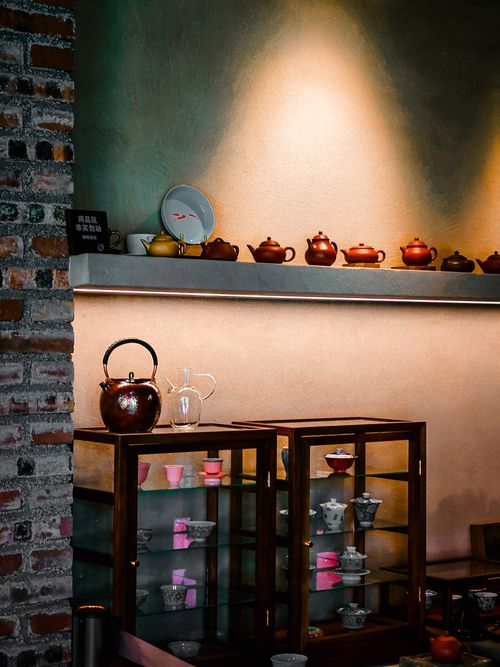 Free A warm and inviting display of teapots and cups in a cozy interior setting, perfect for tea enthusiasts. Stock Photo