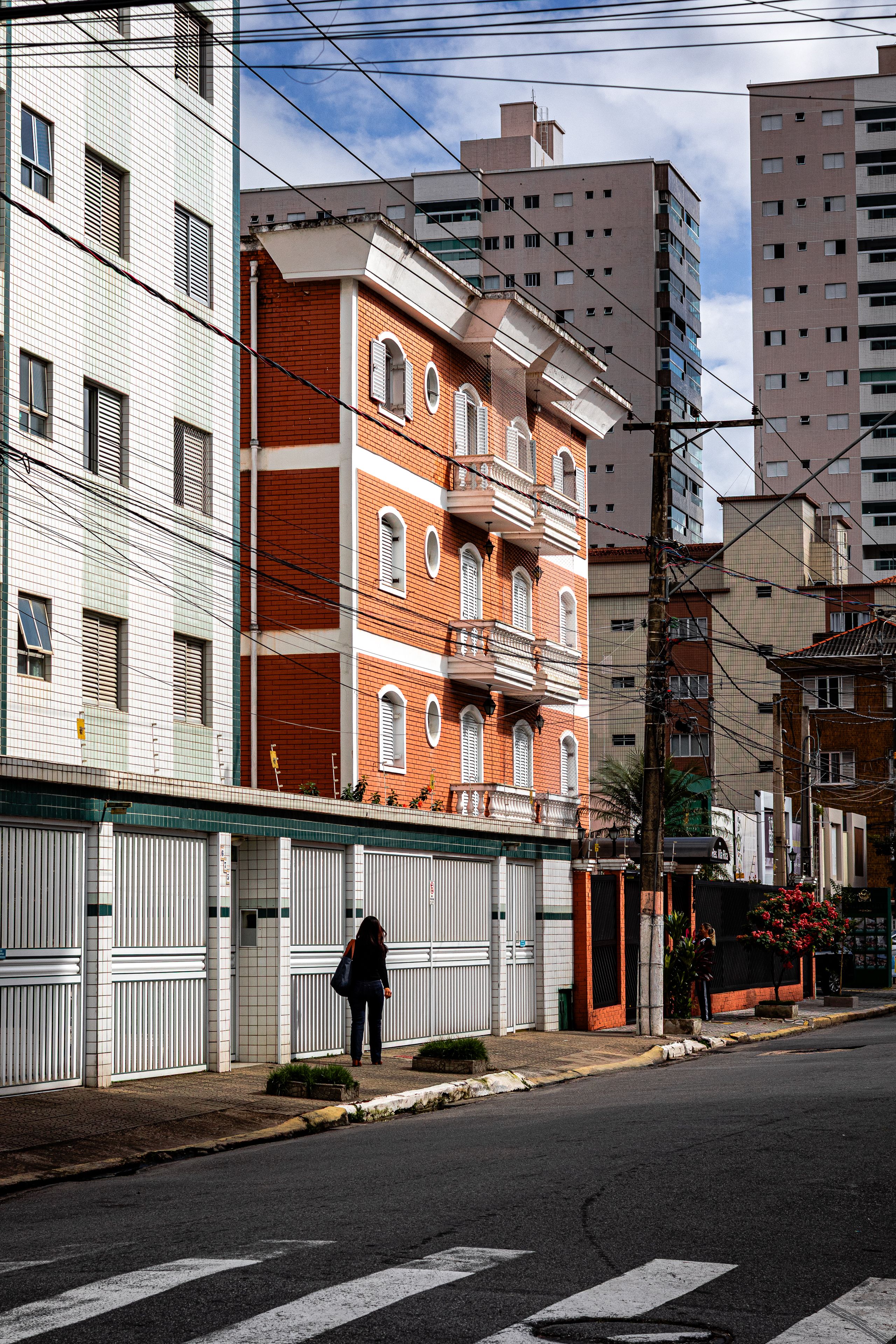 City street view featuring a red brick building under a blue sky.