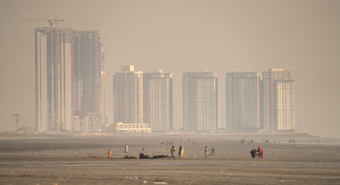 Karachi urban skyline seen across a sandy beach