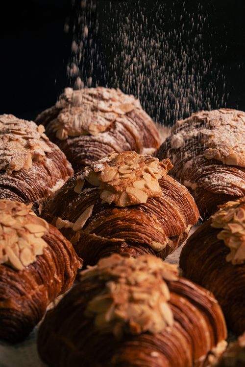 Free Close-up of almond croissants dusted with sugar, showcasing texture and details. Stock Photo