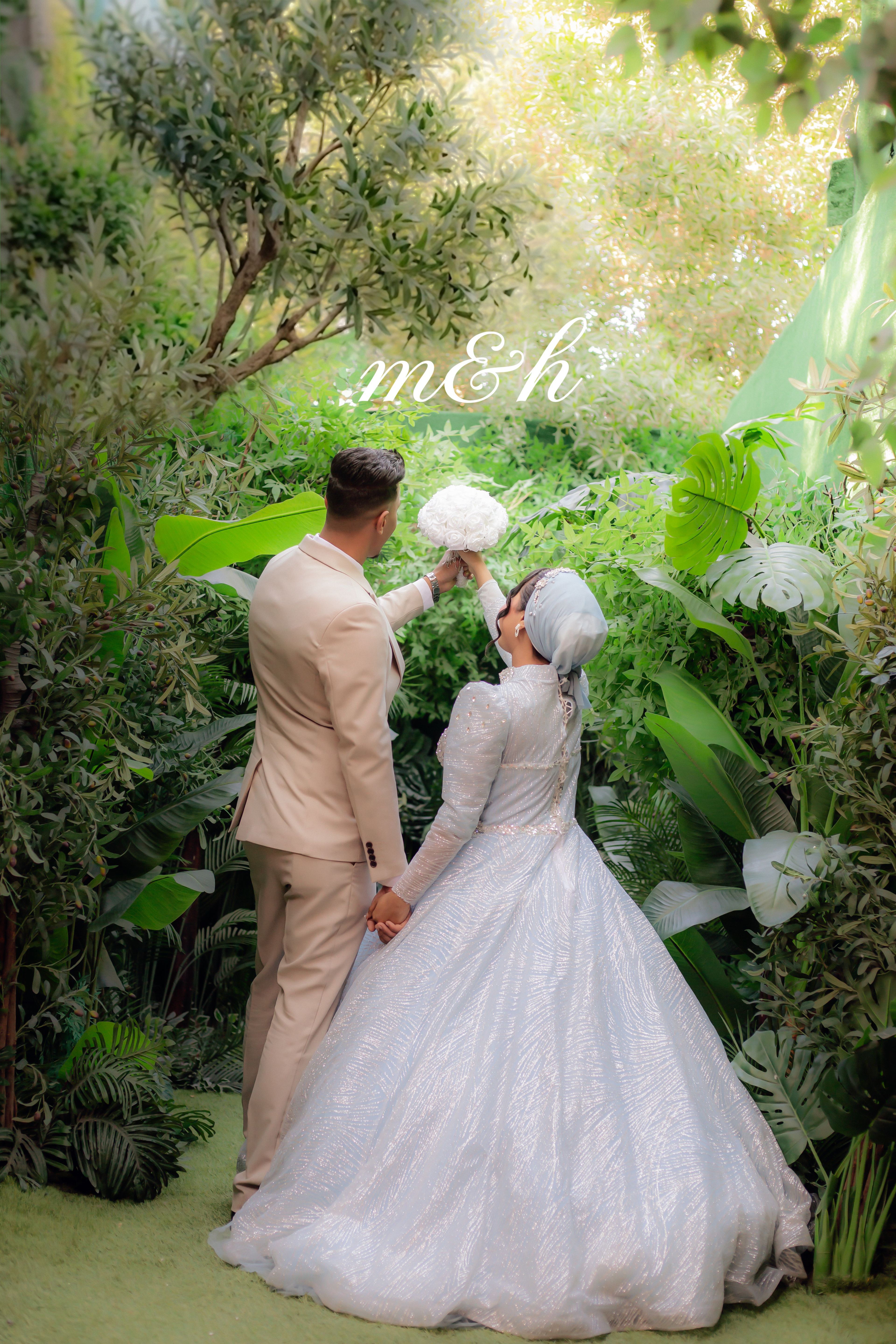 Bride and groom in lush garden setting, celebrating love with a classic touch.