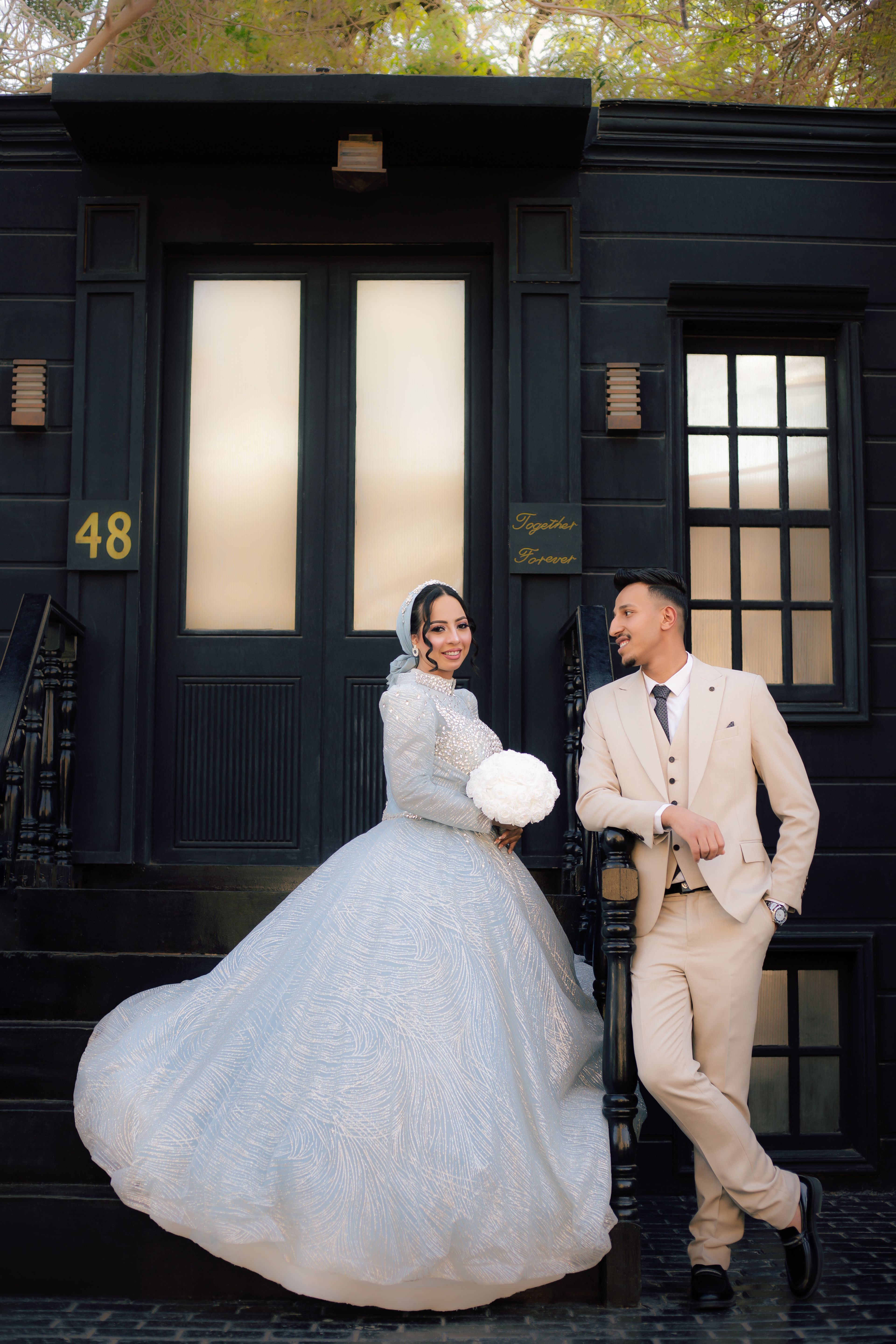 Beautiful outdoor wedding photo with a bride in a gown and groom in a suit.
