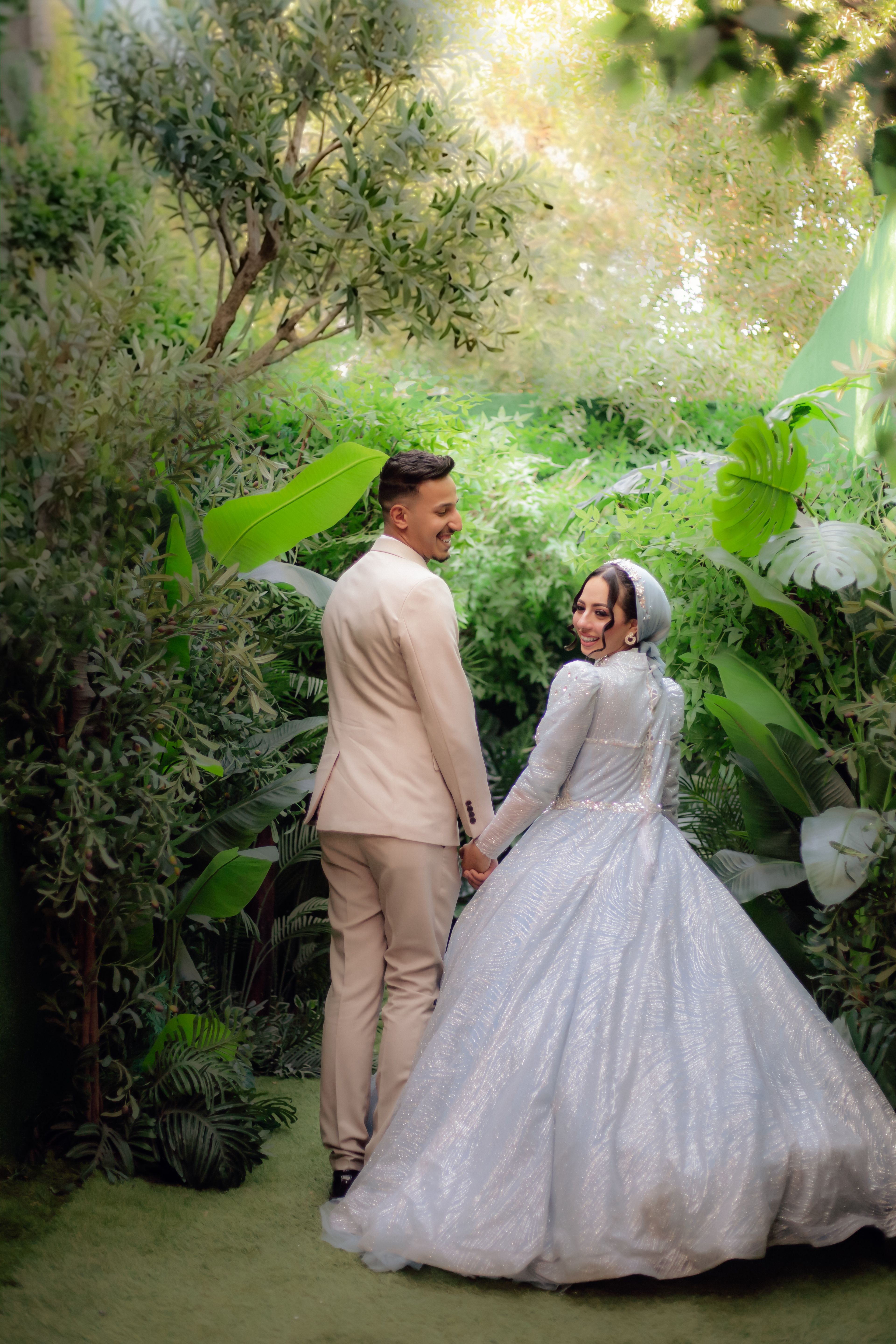 Bride and groom captured in a lush garden setting, exuding romance.